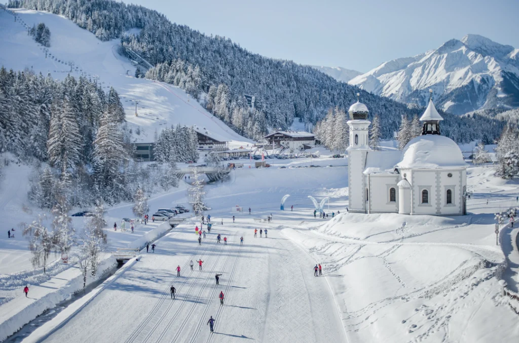 Cross-country skiing in Seefeld, Austria, with a scenic view of the snow-covered village and surrounding mountains.