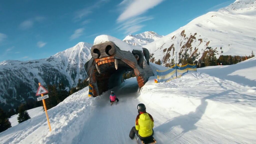 Sledding through a bear-head tunnel on a snowy mountain track.